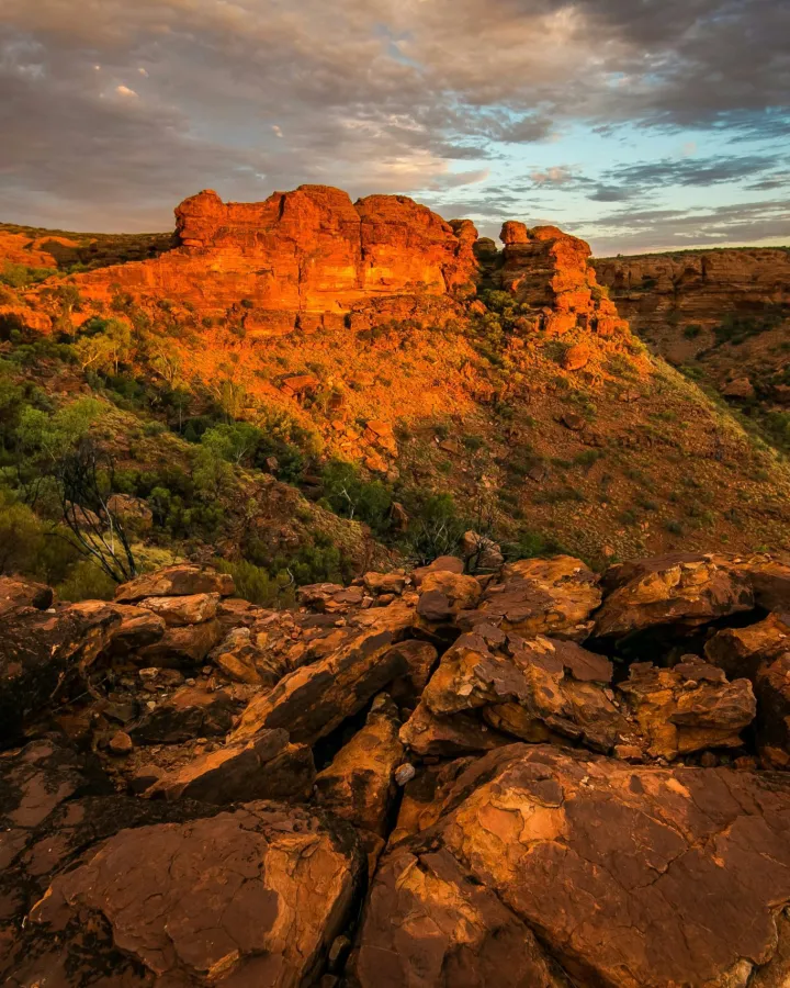 Golden sunlight on red rock formations in Australia's outback.