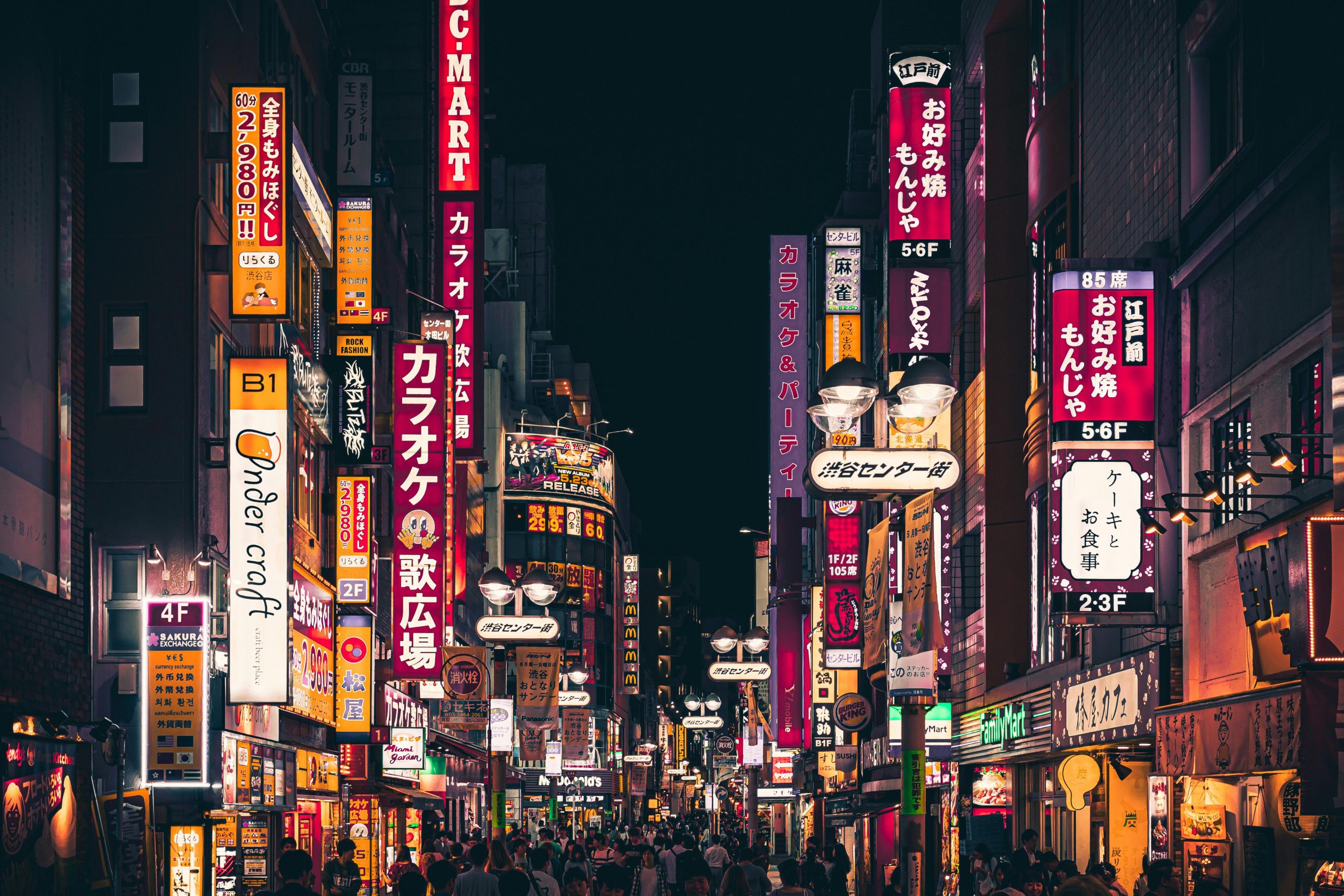 Vibrant Shinjuku nightlife scene with bright neon signs and bustling crowds in Tokyo, Japan.